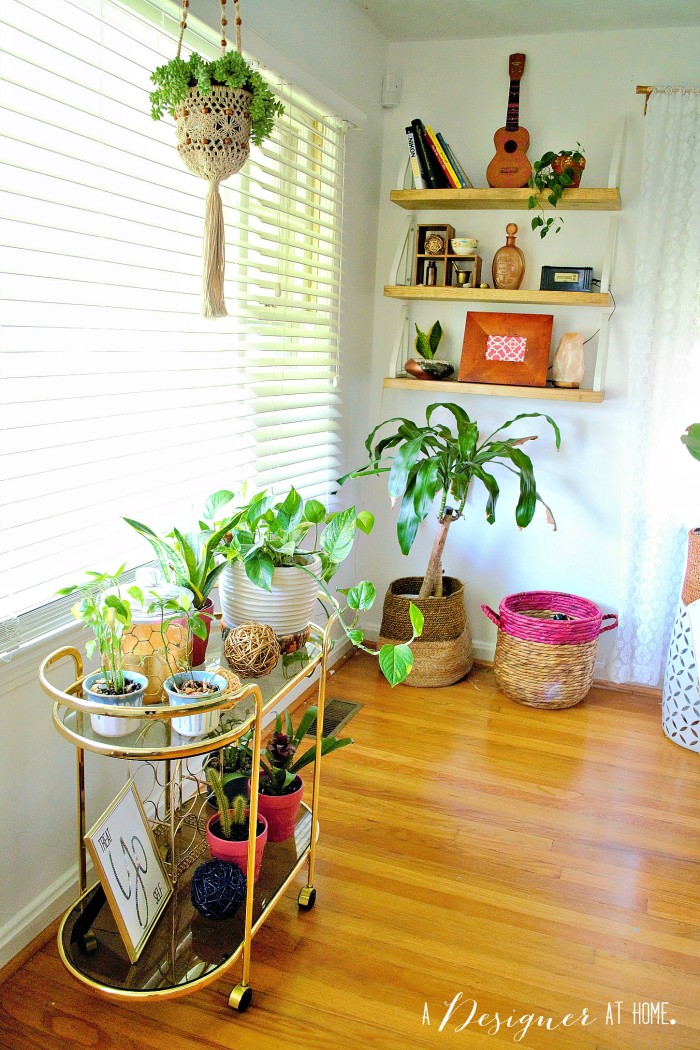 the front window of the house is the perfect place for a bar cart turned plant stand and check out those shelves in the corner! 