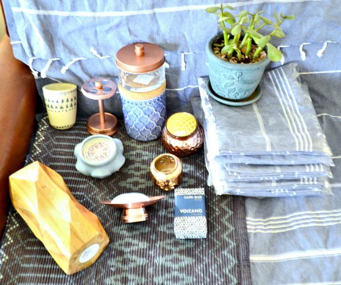 Copper candle holders are Target dollar spot. Copper soap dish and toothbrush holder are Wayfair, Wooden faceted vase, glass lidded jar with copper top (was chrome, spray painted it to match) are Target. Cream tumbler with indigo tribal design, blue jar with cork lid, footed candle and Volcano soap are Anthropologie, the turkish towels are Amazon. The jade plant and pot are a gift from my mom. The rug beneath the decor is Target, clearanced out many months ago from the Threshold line.