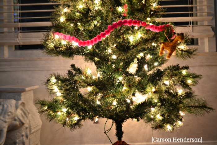 lower-portion-of-fake-christmas-tree-pink-garland-giraffe-ornament