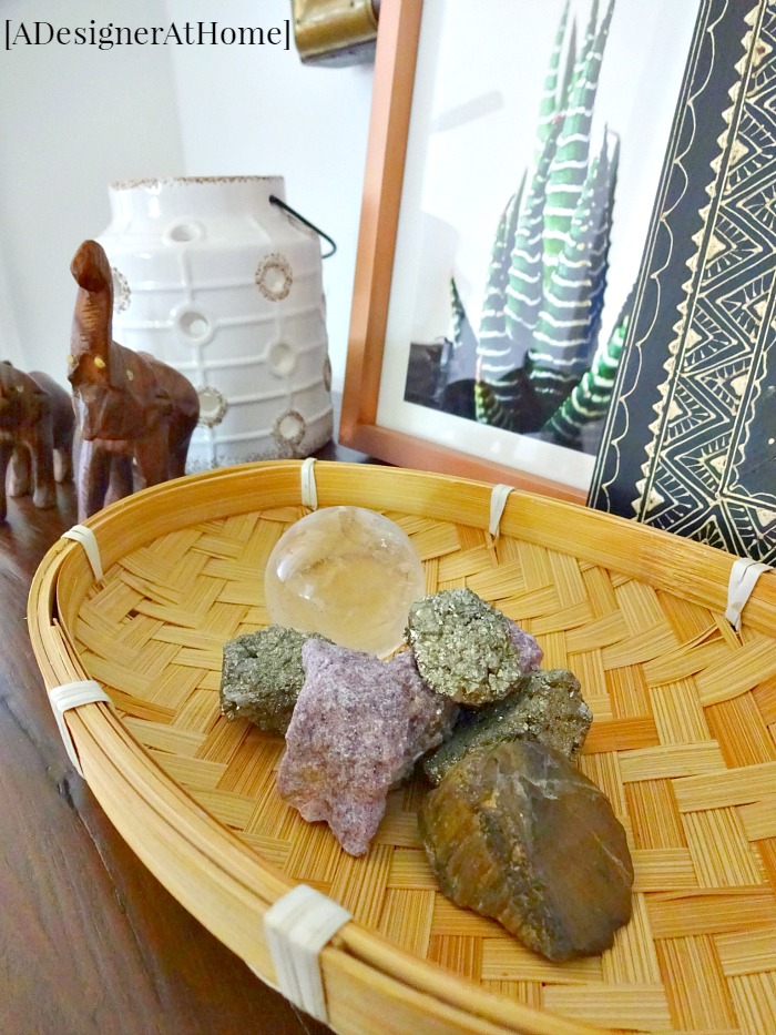 collection of gems, stones and crystals nestled in a thrifted basket complete the cozy feeling for end of the hallway decor