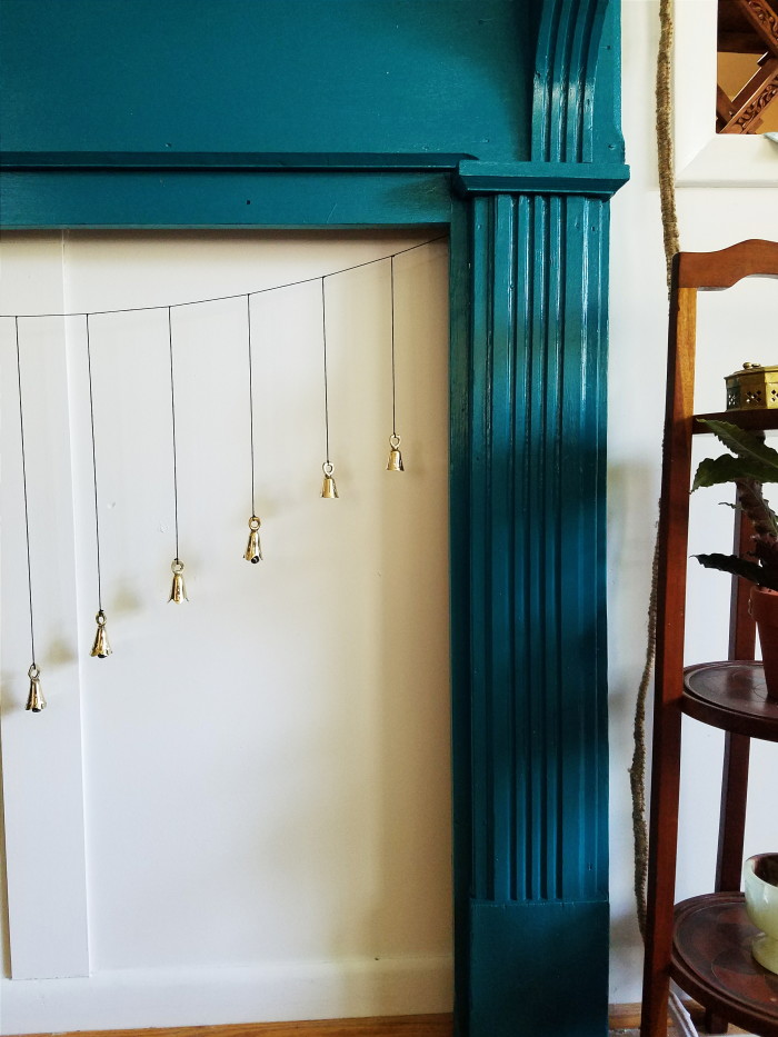 Teal fireplace with hanging bells for faux fireplace screen