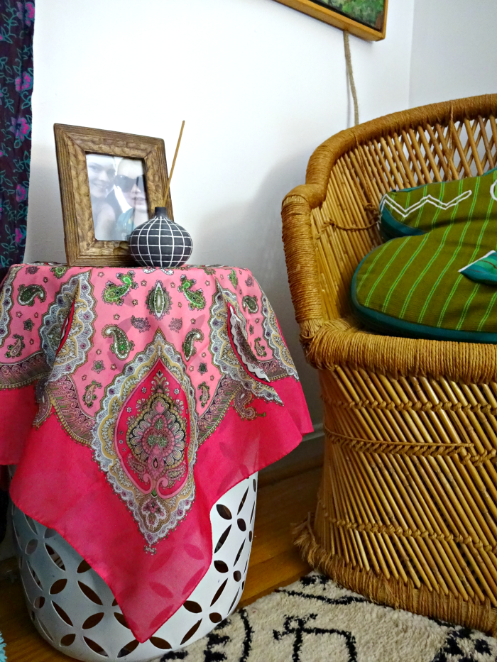 garden stool with pretty pink silk scarf make a simple bedside table when space is tight