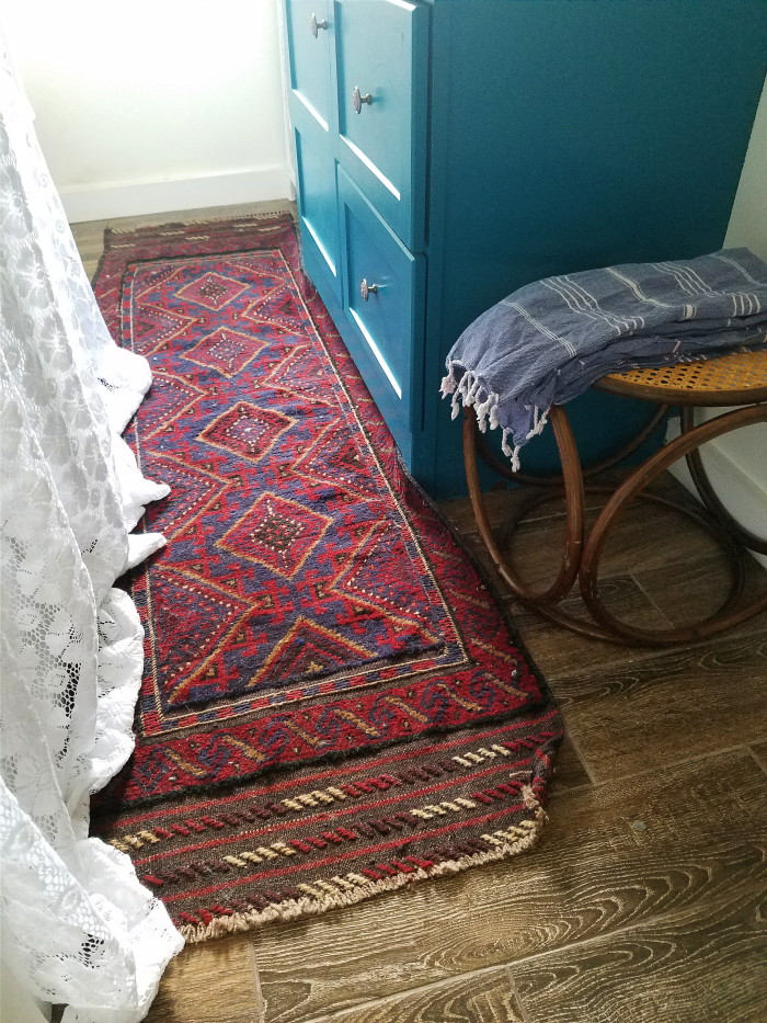 Vintage middle eastern rug with maroon and navy: a vintage bohemian bathroom