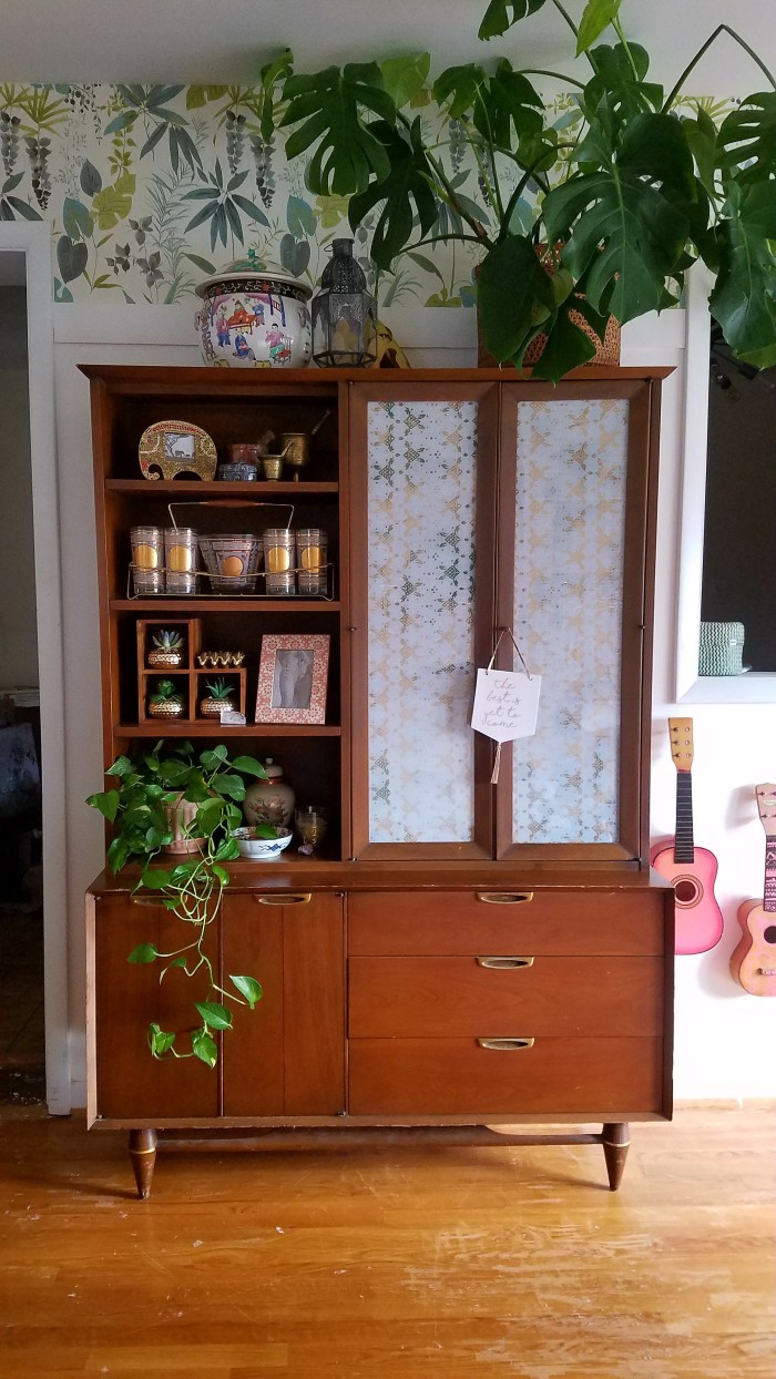 midcentury modern china cabinet with jungle boho wallpaper and lush plants