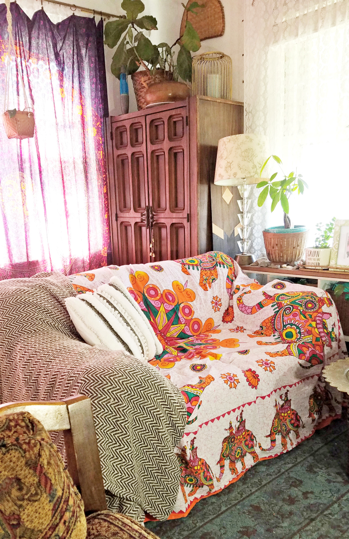 colorful boho elephant tapestry covered light denim wash of old hand me down sofa made cozy with a chevron cotton throw and a DIY handira inspired pillow