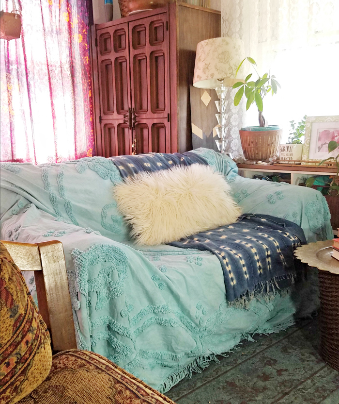 old sofa covered in turquoise hand dyed bed coverlet with indigo mudcloth and mongolian fur pillow- hand me down sofa done bohemian